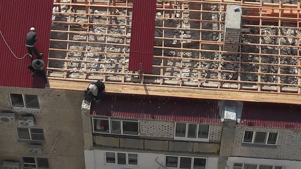 В Атырау строители чинили крышу многоэтажки без страховки (ВИДЕО)